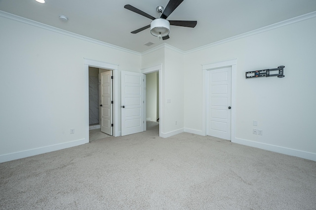 unfurnished bedroom with ornamental molding, carpet flooring, baseboards, a ceiling fan, and ensuite bath