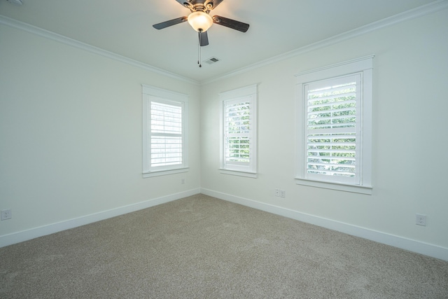 empty room with ornamental molding, carpet, healthy amount of natural light, baseboards, and ceiling fan