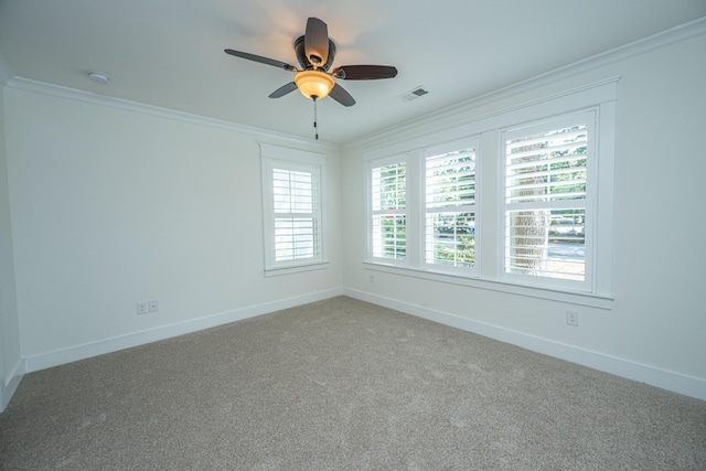 empty room with ornamental molding, ceiling fan, light colored carpet, baseboards, and a smoke detector