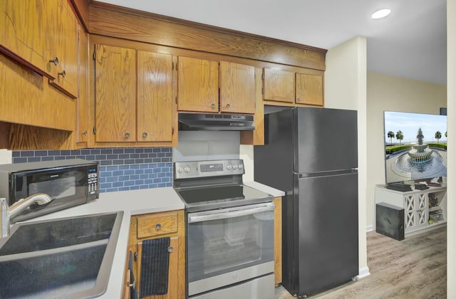 kitchen with sink, light hardwood / wood-style floors, and black appliances