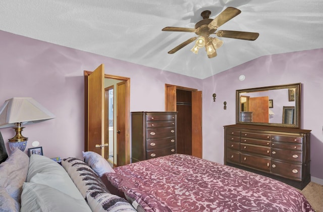 bedroom featuring ceiling fan, vaulted ceiling, and a textured ceiling