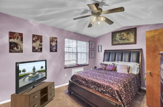 bedroom featuring vaulted ceiling, dark carpet, a textured ceiling, and ceiling fan