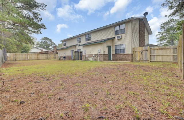 rear view of property with a wall mounted air conditioner and a lawn