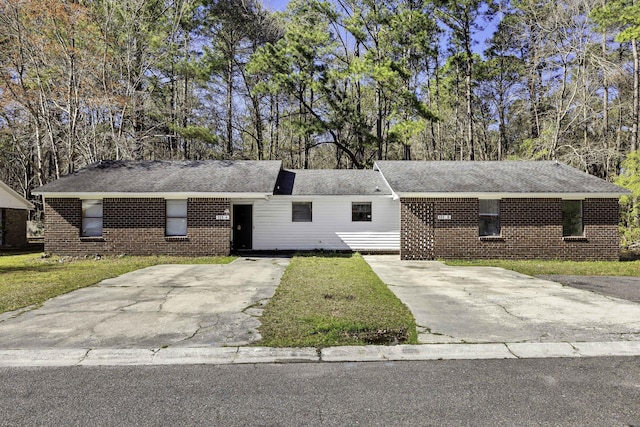 ranch-style house with brick siding, driveway, and a front yard