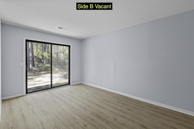 unfurnished room with visible vents, baseboards, and wood finished floors