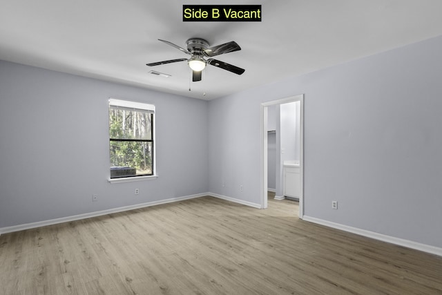 spare room featuring a ceiling fan, wood finished floors, visible vents, and baseboards