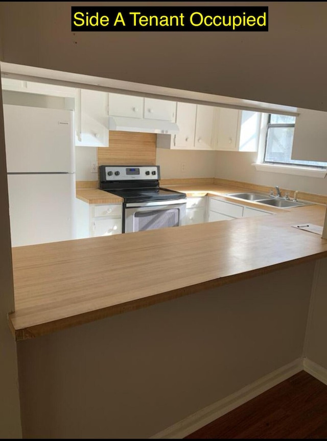 kitchen with under cabinet range hood, stainless steel electric stove, light countertops, white cabinetry, and a sink