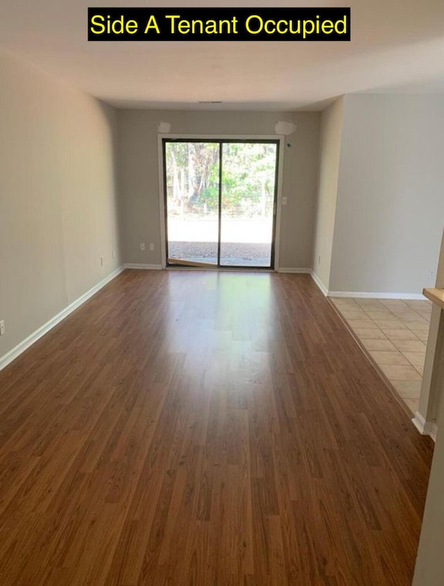 unfurnished room with wood finished floors and baseboards