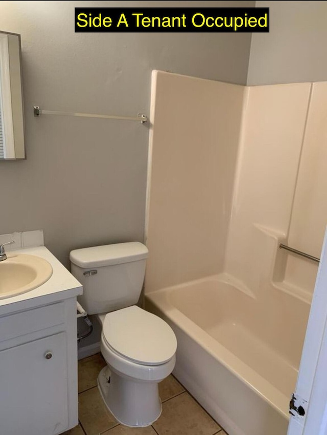 bathroom with tile patterned flooring, bathing tub / shower combination, toilet, and vanity