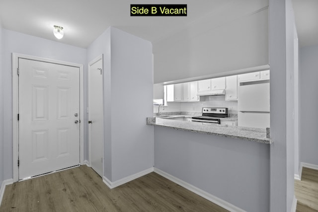 kitchen with a sink, white fridge, stainless steel range with electric cooktop, under cabinet range hood, and white cabinetry