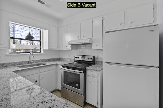 kitchen featuring visible vents, stainless steel electric range, freestanding refrigerator, a sink, and under cabinet range hood