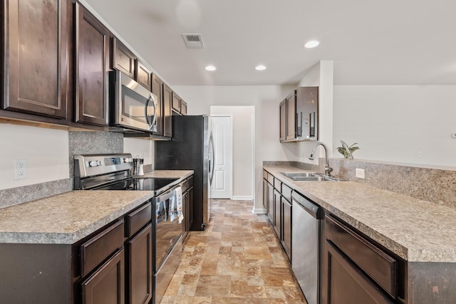 251 Coosawatchie St, Summerville, SC 29485 - kitchen featuring stainless steel appliances, a sink, dark brown cabinetry, light stone finish flooring, and a peninsula