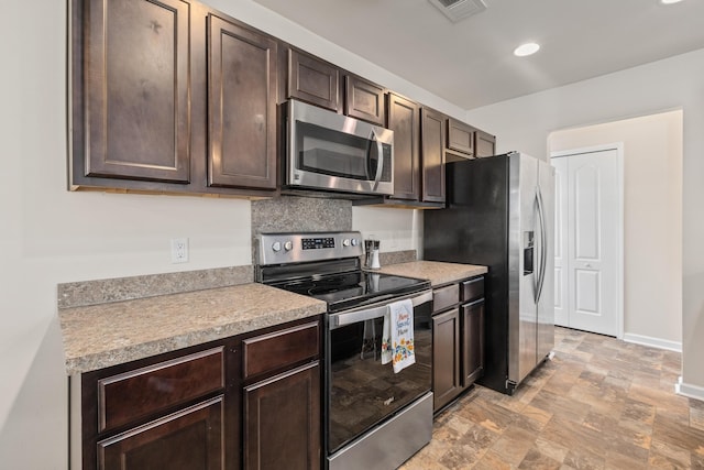 251 Coosawatchie St, Summerville, SC 29485 - kitchen featuring appliances with stainless steel finishes, dark brown cabinetry, light countertops, stone finish flooring, and baseboards