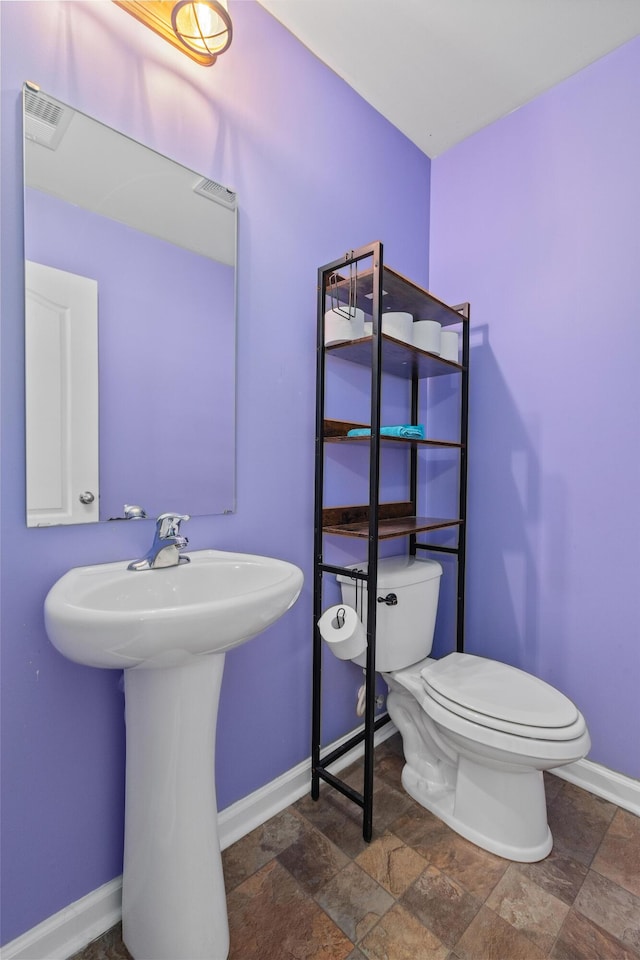 251 Coosawatchie St, Summerville, SC 29485 - bathroom with stone finish flooring, baseboards, toilet, and a sink