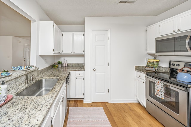 1918 Piper Dr, Charleston, SC 29407 - kitchen featuring stainless steel appliances, a sink, light wood-style flooring, light stone countertops, and white cabinetry
