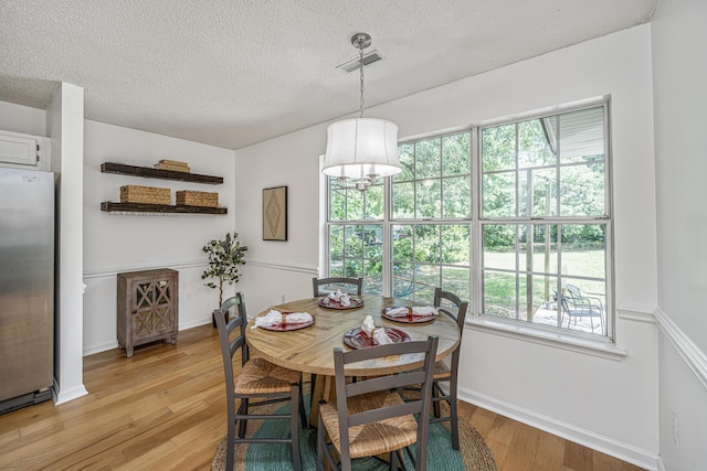 1918 Piper Dr, Charleston, SC 29407 - dining space with light wood-type flooring, a textured ceiling, and baseboards