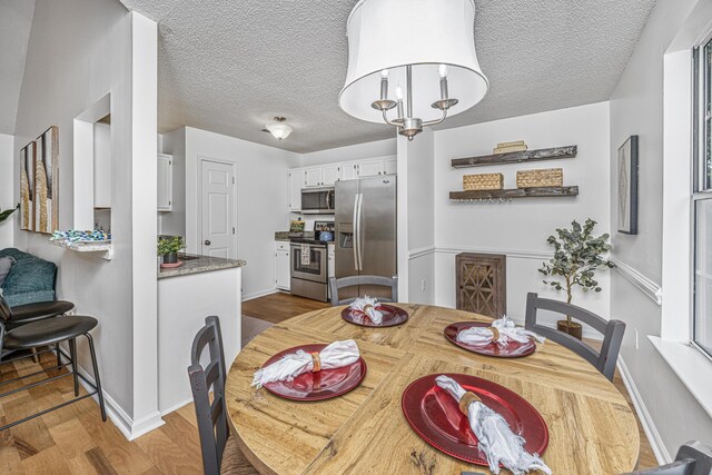 1918 Piper Dr, Charleston, SC 29407 - dining room with wood finished floors, a textured ceiling, and baseboards