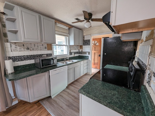 kitchen featuring white cabinets, dishwasher, refrigerator, and light hardwood / wood-style floors