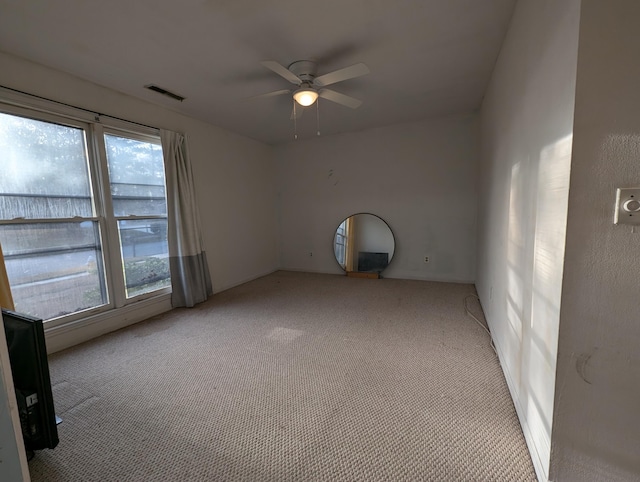 carpeted spare room with a wealth of natural light and ceiling fan