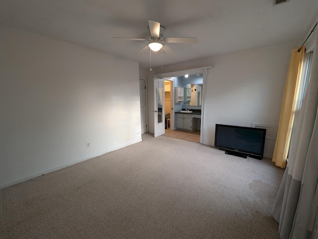 unfurnished living room featuring light carpet and ceiling fan