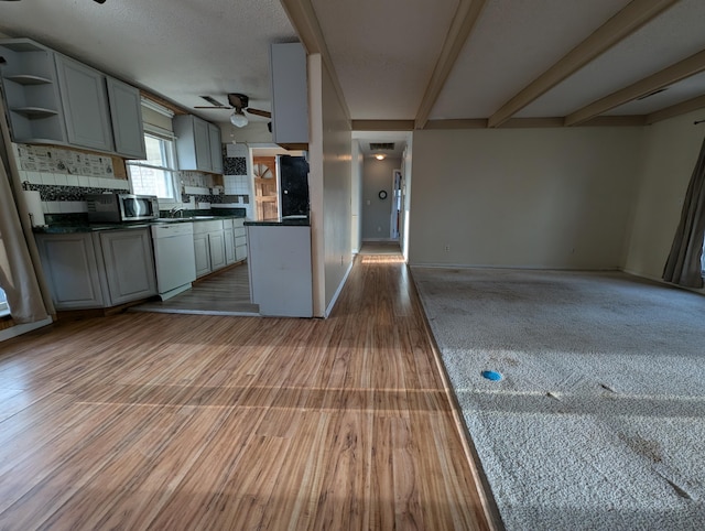 kitchen featuring beam ceiling, dishwasher, tasteful backsplash, gray cabinets, and light wood-type flooring