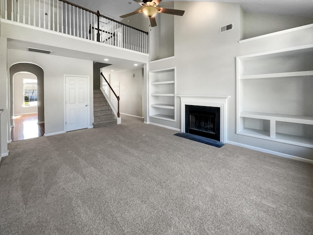 unfurnished living room with built in shelves, carpet, and visible vents