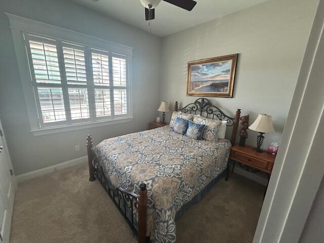 carpeted bedroom featuring baseboards and a ceiling fan