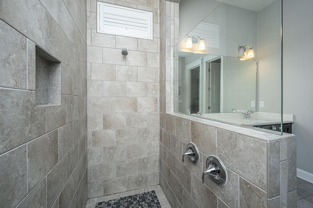 full bathroom with a sink and a tile shower