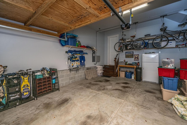 garage featuring a garage door opener and freestanding refrigerator