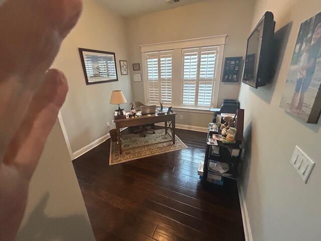 office space featuring baseboards, visible vents, and hardwood / wood-style flooring