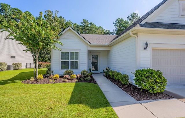 doorway to property with a yard, central AC, and a garage