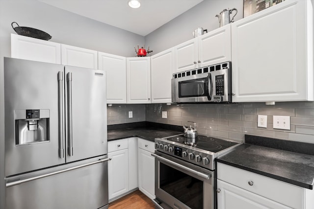 1431 Whispering Oak Trl, Mount Pleasant, SC 29466 - kitchen with appliances with stainless steel finishes, dark countertops, decorative backsplash, white cabinetry, and recessed lighting