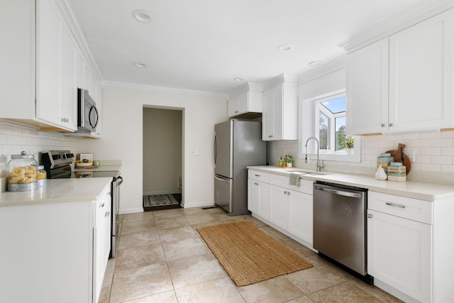 kitchen with white cabinets, stainless steel appliances, crown molding, and sink