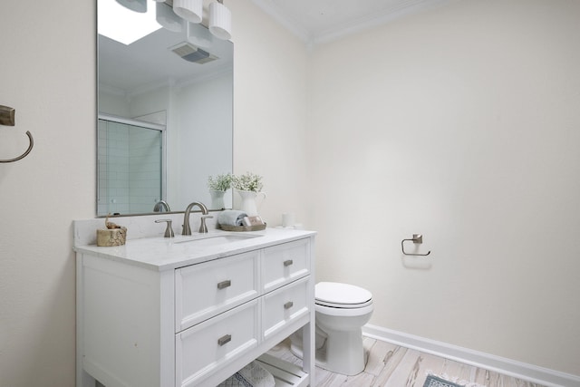 bathroom featuring vanity, a shower with door, crown molding, wood-type flooring, and toilet