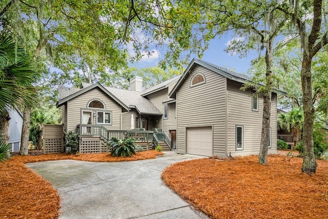 view of front of house featuring a garage, a chimney, concrete driveway, and roof with shingles