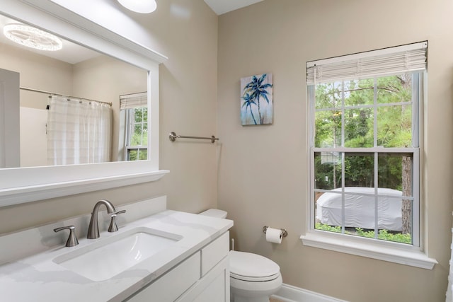 full bathroom featuring baseboards, a shower with shower curtain, vanity, and toilet