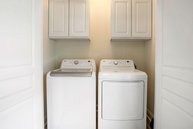 washroom featuring cabinet space and independent washer and dryer