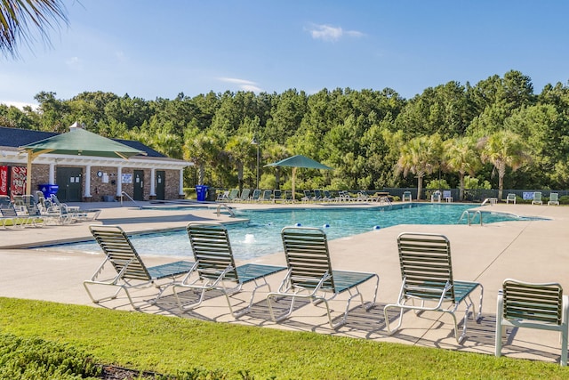 community pool with a patio and fence