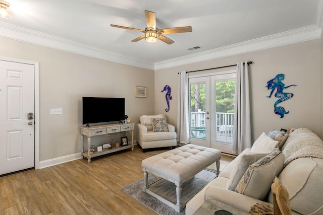 living area featuring ceiling fan, visible vents, ornamental molding, french doors, and light wood-type flooring