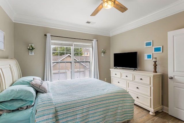 bedroom featuring crown molding, visible vents, ceiling fan, and wood finished floors