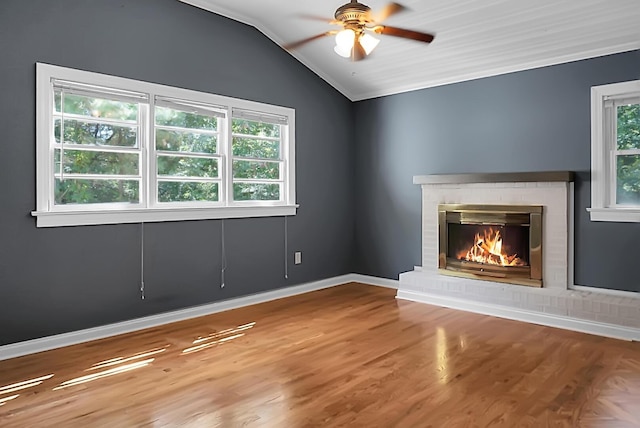 unfurnished living room with vaulted ceiling, a brick fireplace, hardwood / wood-style floors, and ceiling fan