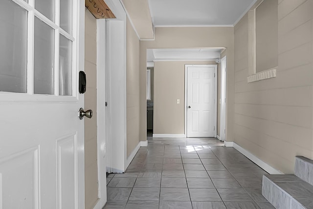 hallway with crown molding and light tile patterned floors