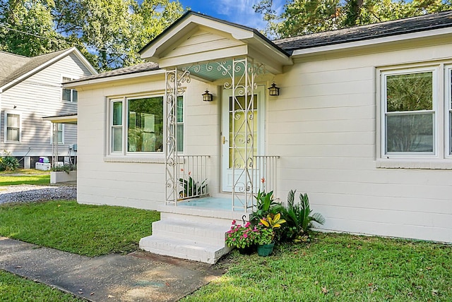 property entrance with a lawn