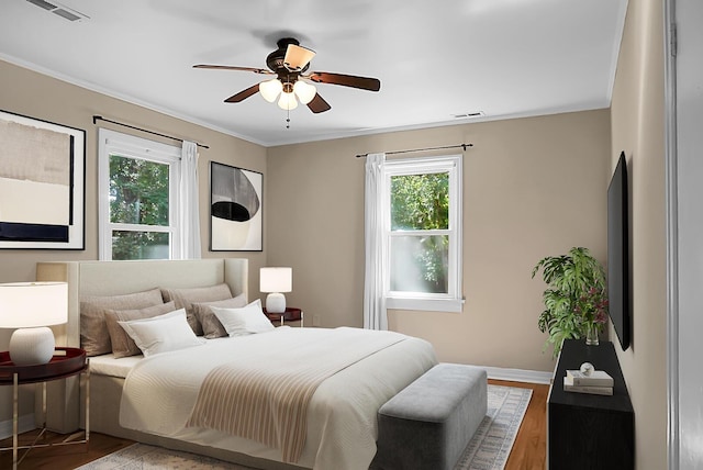 bedroom with ceiling fan, ornamental molding, and hardwood / wood-style floors