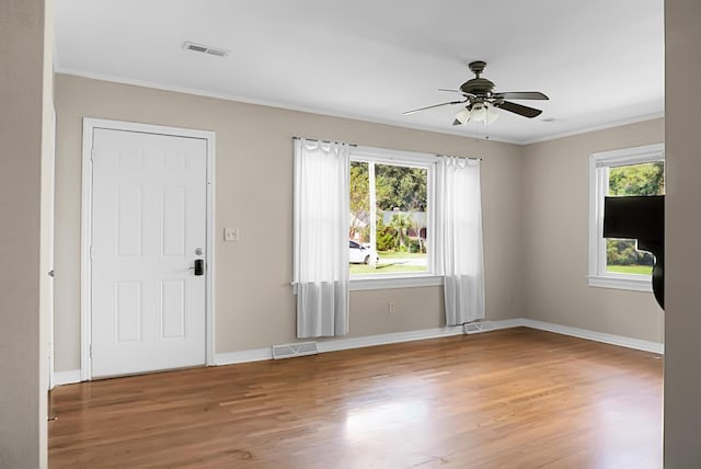 foyer featuring wood-type flooring, ornamental molding, and ceiling fan