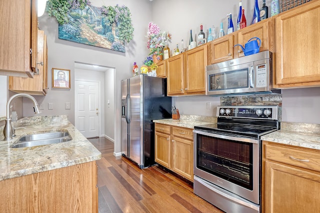 kitchen featuring stainless steel appliances, dark wood-type flooring, a sink, baseboards, and light countertops