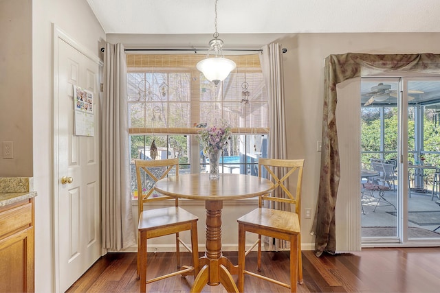 dining room featuring ceiling fan, dark wood finished floors, and baseboards