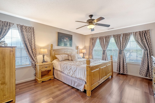 bedroom with multiple windows and wood finished floors