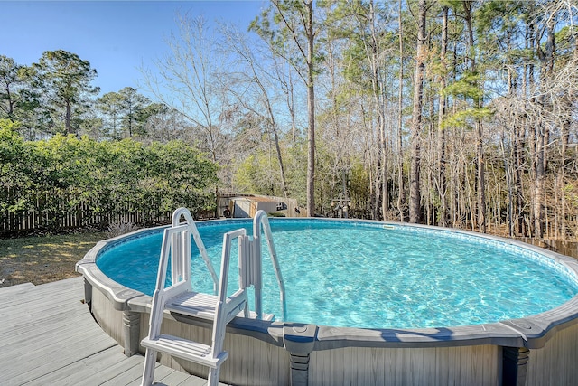 outdoor pool with a jacuzzi, a deck, and a fenced backyard