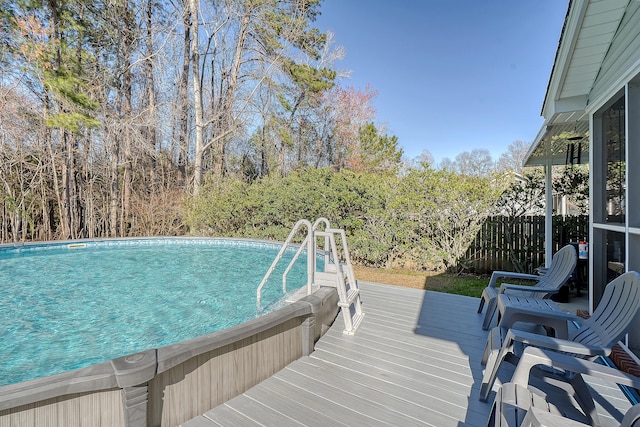 pool featuring fence and a deck